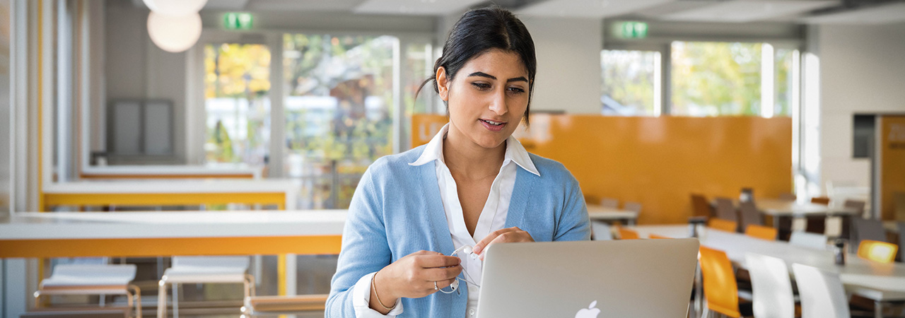 Eine Studentin informiert sich am Laptop über eine Bewerbung bei BMW.
