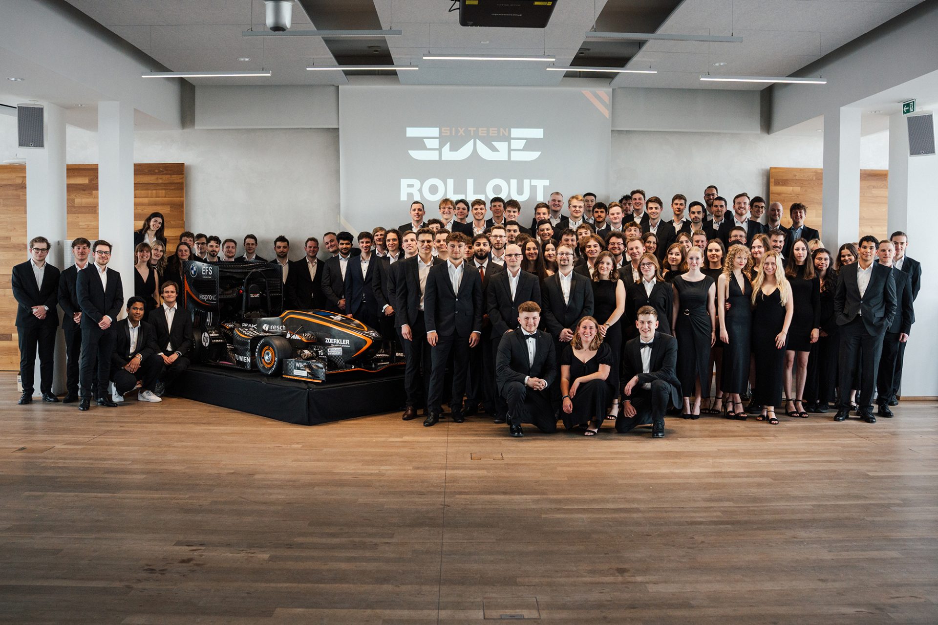 Gruppenfoto von TU Wien Racing zusammen mit dem Fahrzeug.