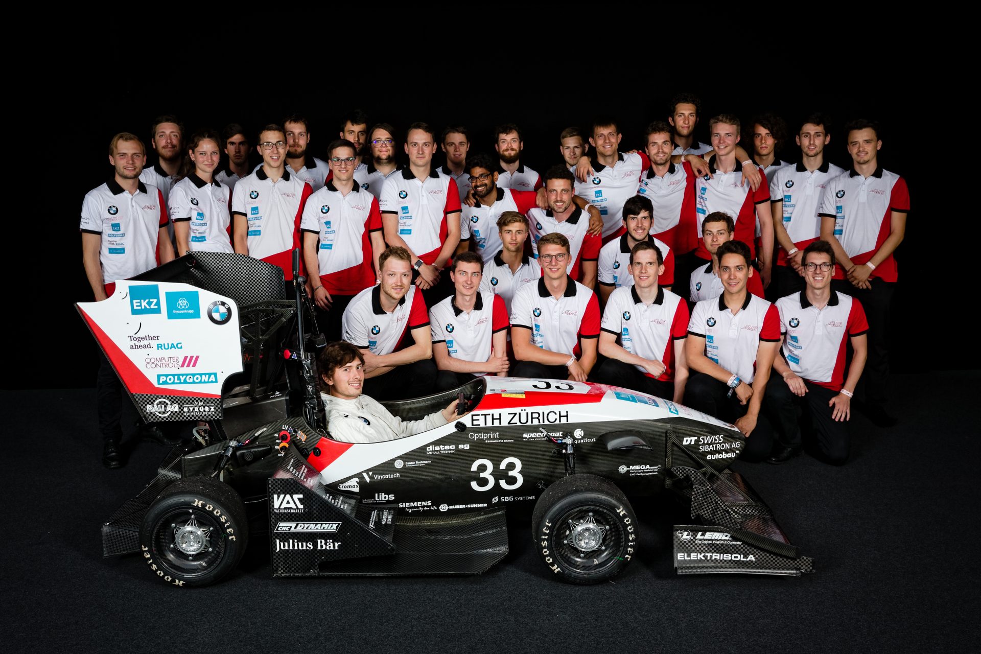 Gruppenbild des AMZ Racing Team mit einem Fahrzeug.