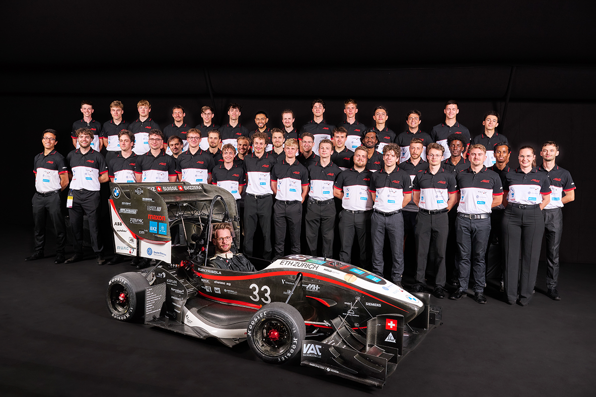 Gruppenbild des AMZ Racing Team mit einem Fahrzeug.