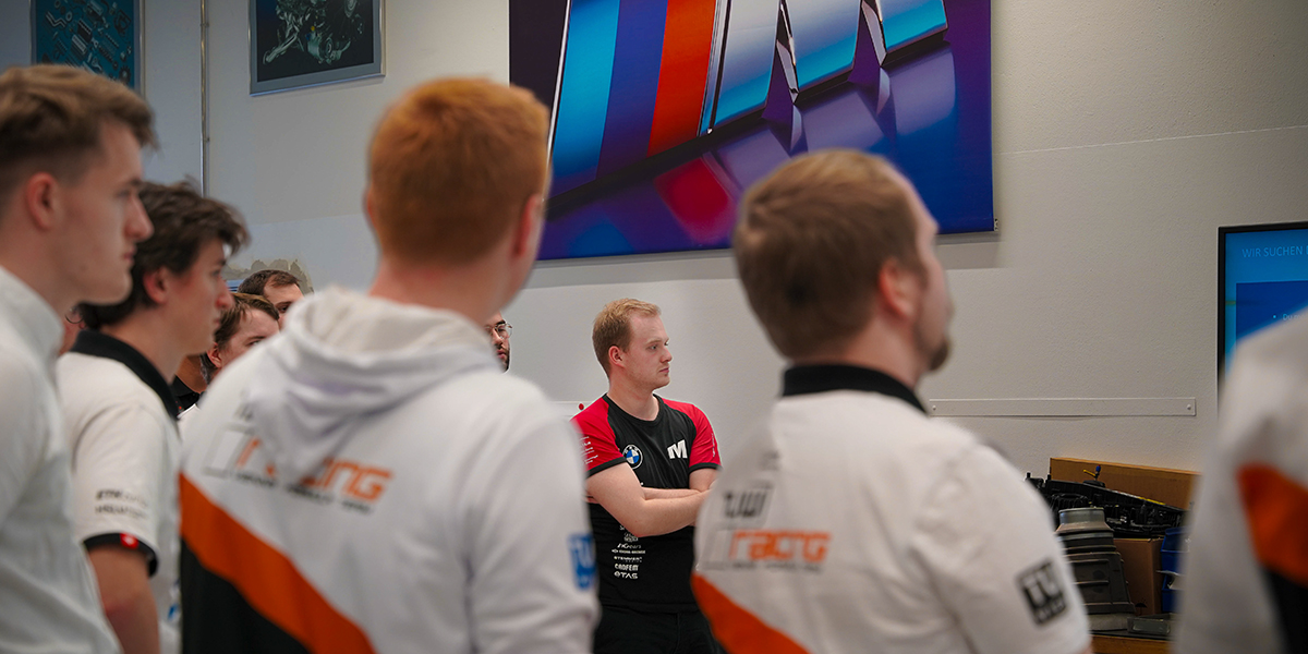 Eine Gruppe von Personen auf dem Formula Student FIZ Event 2024 die aufmerksam zuhören.