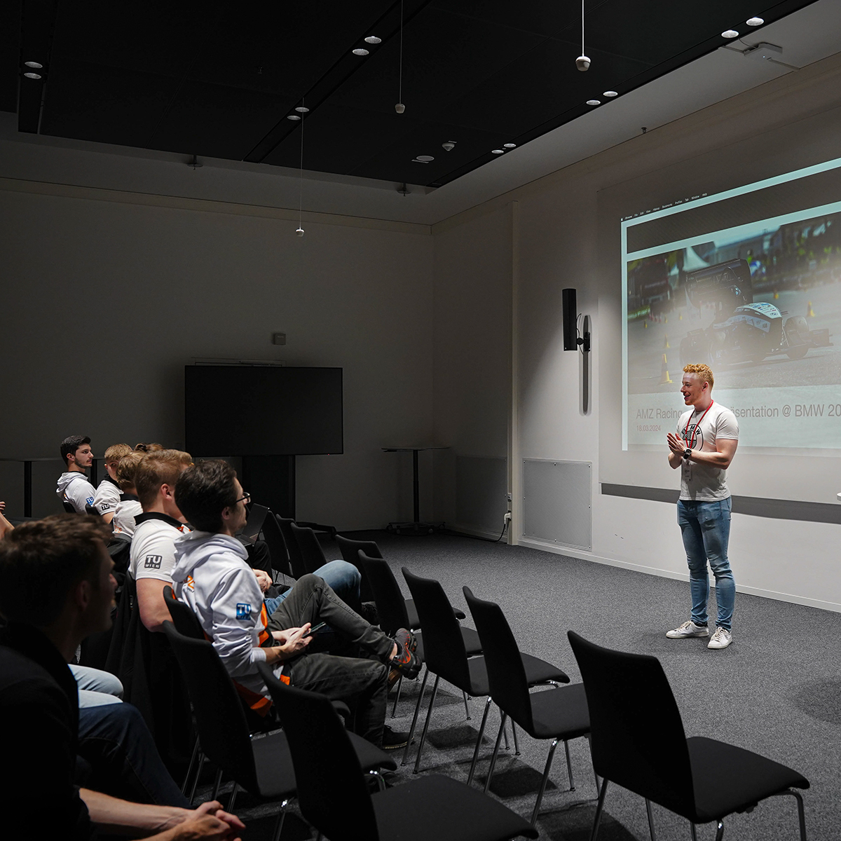 AMZ Racing Team bei einer Präsentation in einem Konferenzraum.