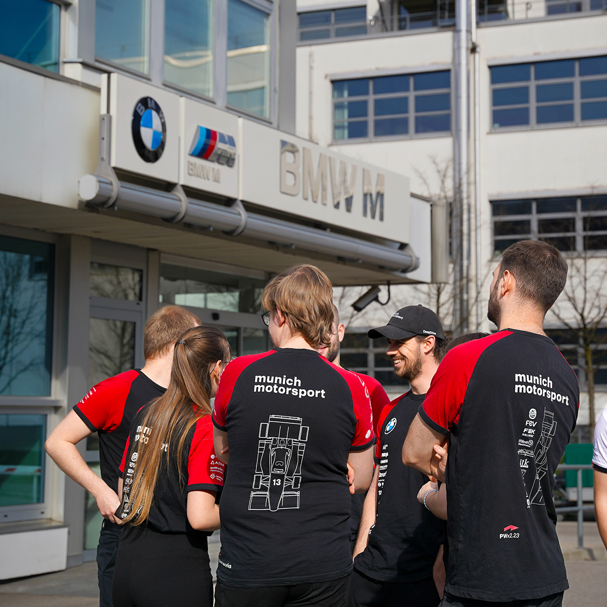 Eine Gruppe Studenten auf dem Formula Student FIZ Event 2024 vor dem BMW Gebäude.