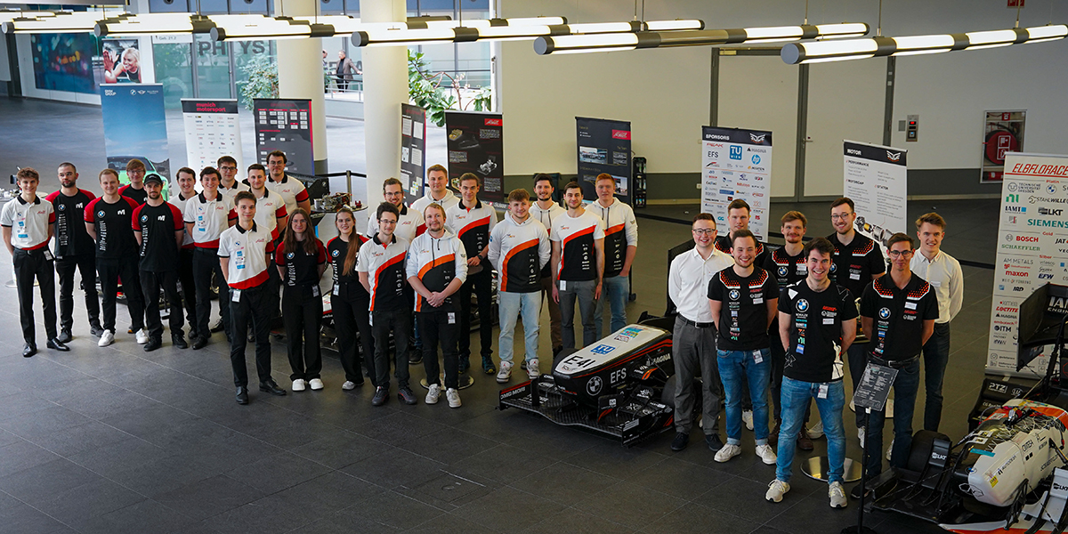 Gruppenfoto des BMW Formula Student Teams mit Rennwagen.