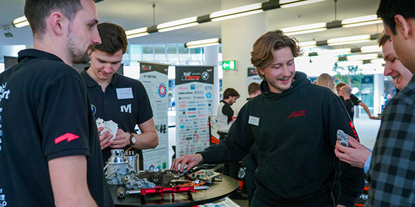 Eine Gruppe von Personen auf dem Formula Student FIZ Event 2024 die aufmerksam zuhören.