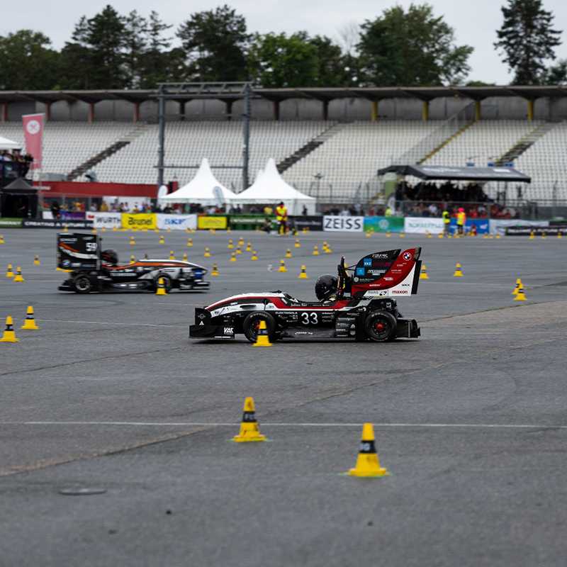Formula Student Fahrer mit seinem Fahrzeug auf der Teststrecke.