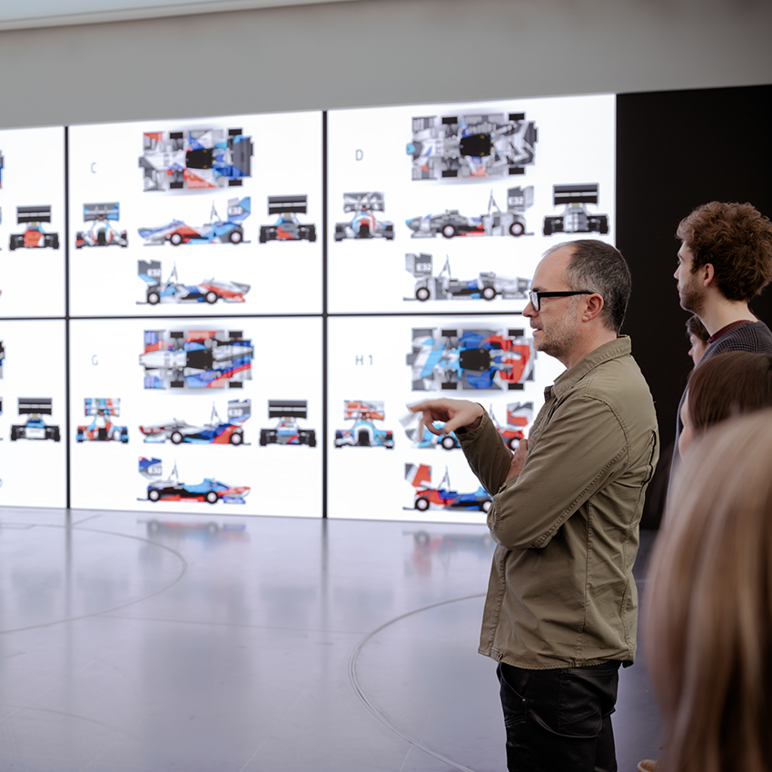 Eine Gruppe Studenten unterhält sich mit BMW M Design Mitarbeitern über verschiedene Design vorschläge.