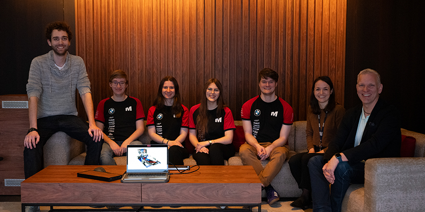 Vier Studenten sitzen zusammen mit 3 BMW Design Mitarbeitern.