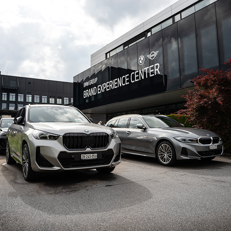 Zwei BMW Autos vor dem Brand Experience Center der BMW Group in der Schweiz