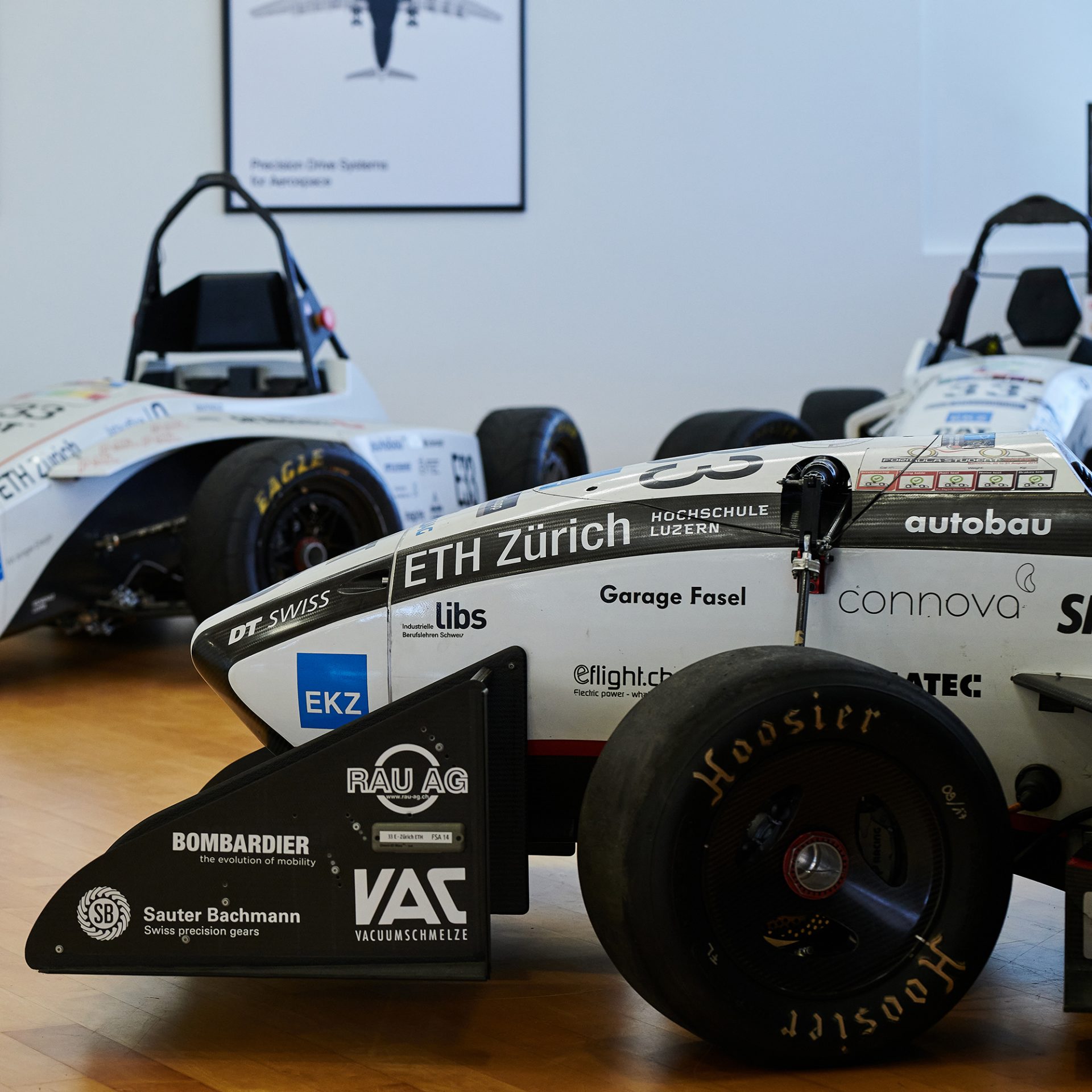 Zwei weiße Fahrzeuge von AMZ Racing.