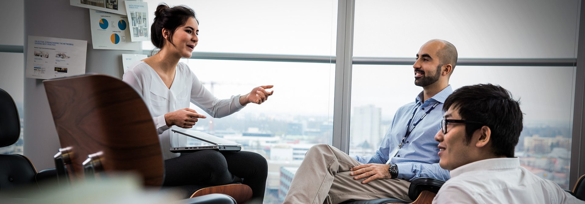 Zwei BMW Group Mitarbeiter und ein Student sitzen zusammen und unterhalten sich.