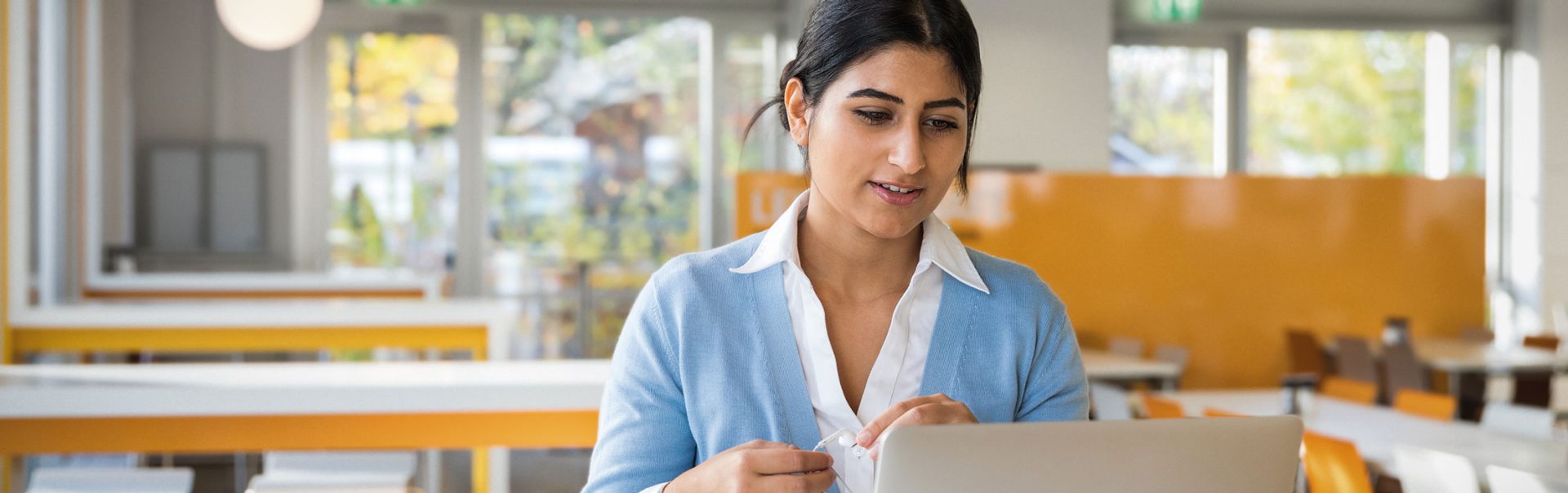 Eine Studentin informiert sich am Laptop über eine Bewerbung bei der BMW Group.