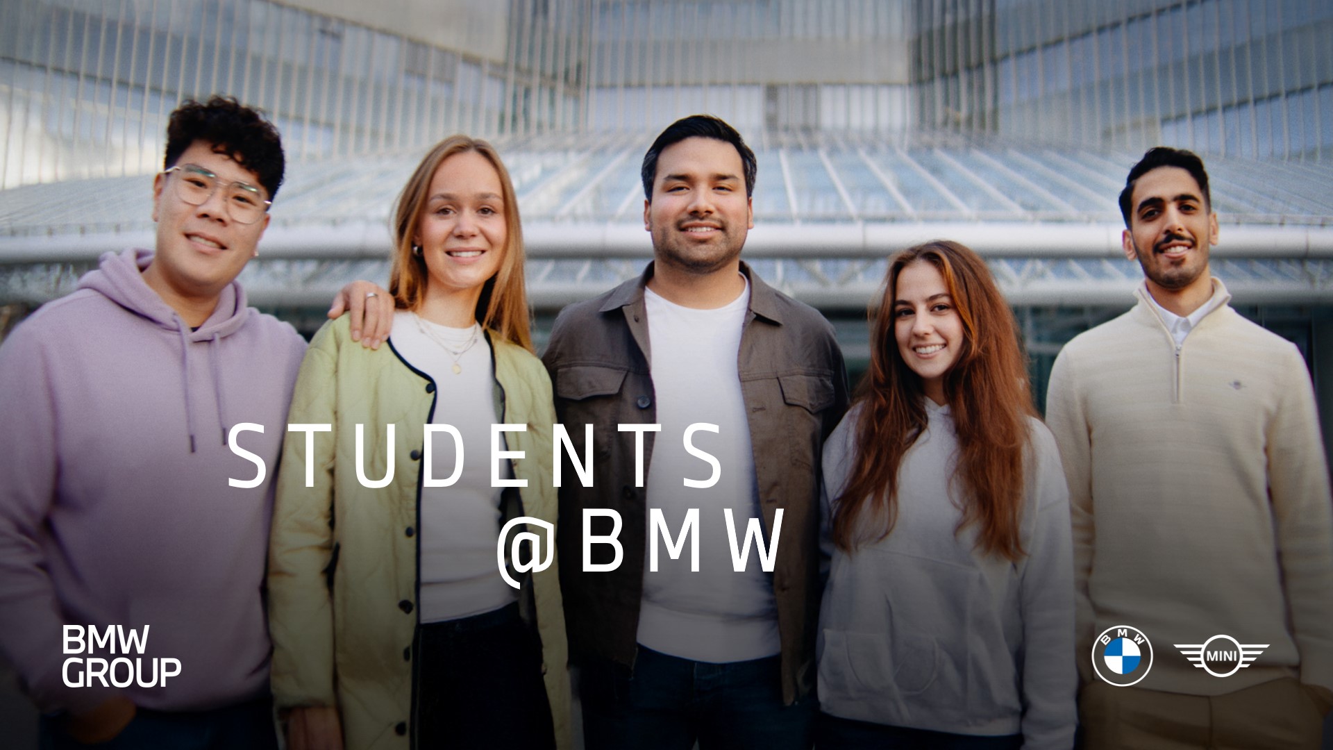 Fünf Studierende bei der BMW Group lachen und posieren lässig vor der Kamera