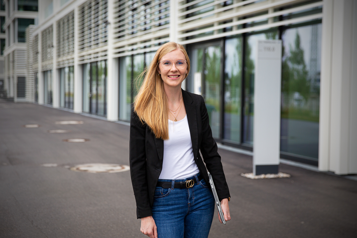 A trainee in the "Acceleration" Programme at the BMW Group smiling at the camera.