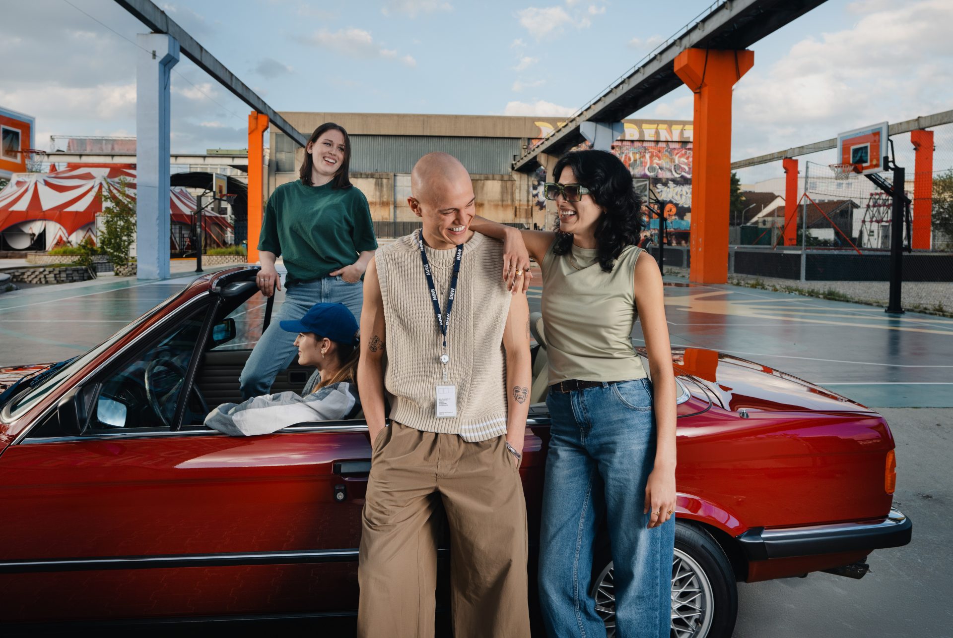 Vier Studierende mit einem BMW E30 Cabrio auf einem urbanen Basketballplatz