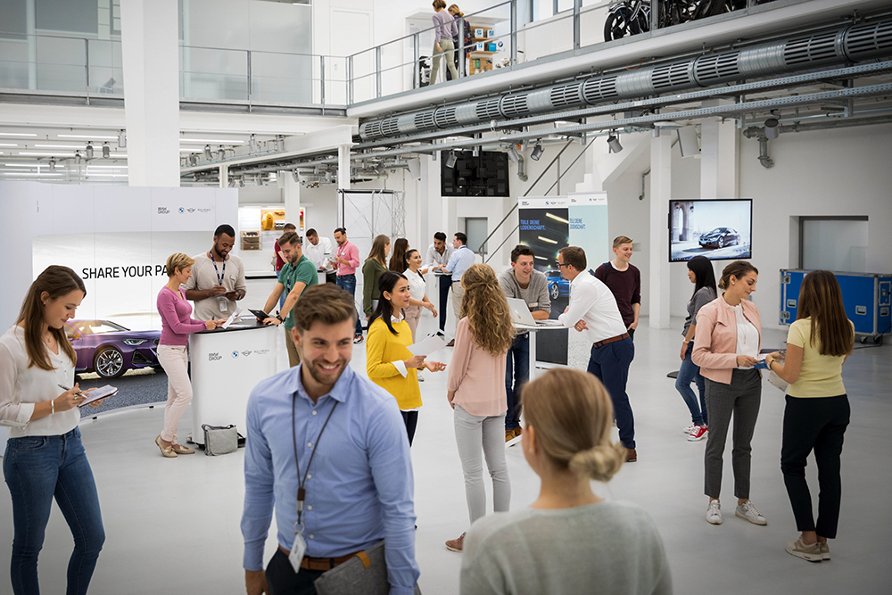 Infostände mit sich unterhaltenden Personen.