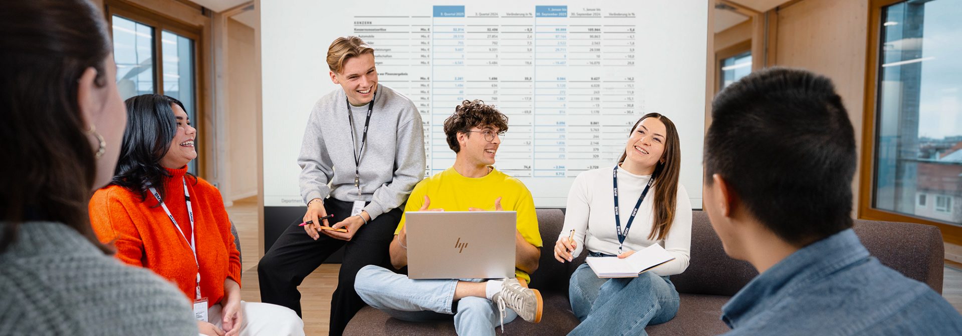 Eine Gruppe Studierender bei einer angeregten Unterhaltung in einem modernen Büro