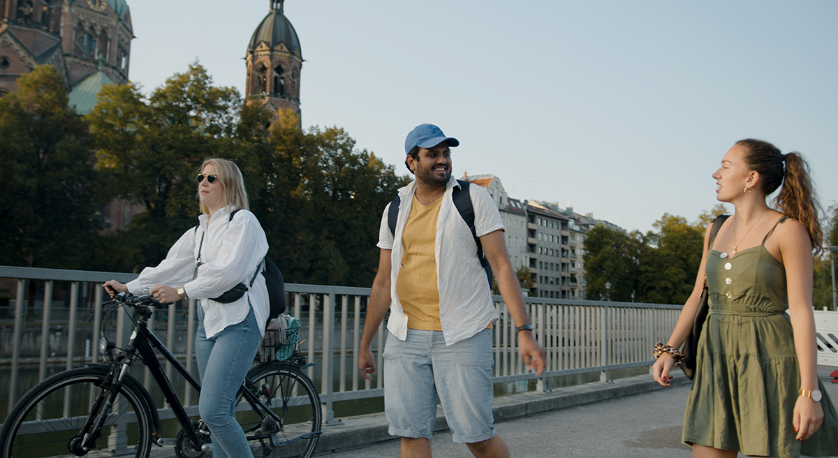 Drei Kollegen der BMW Group bei einem Spanziergang an der Isar in München.
