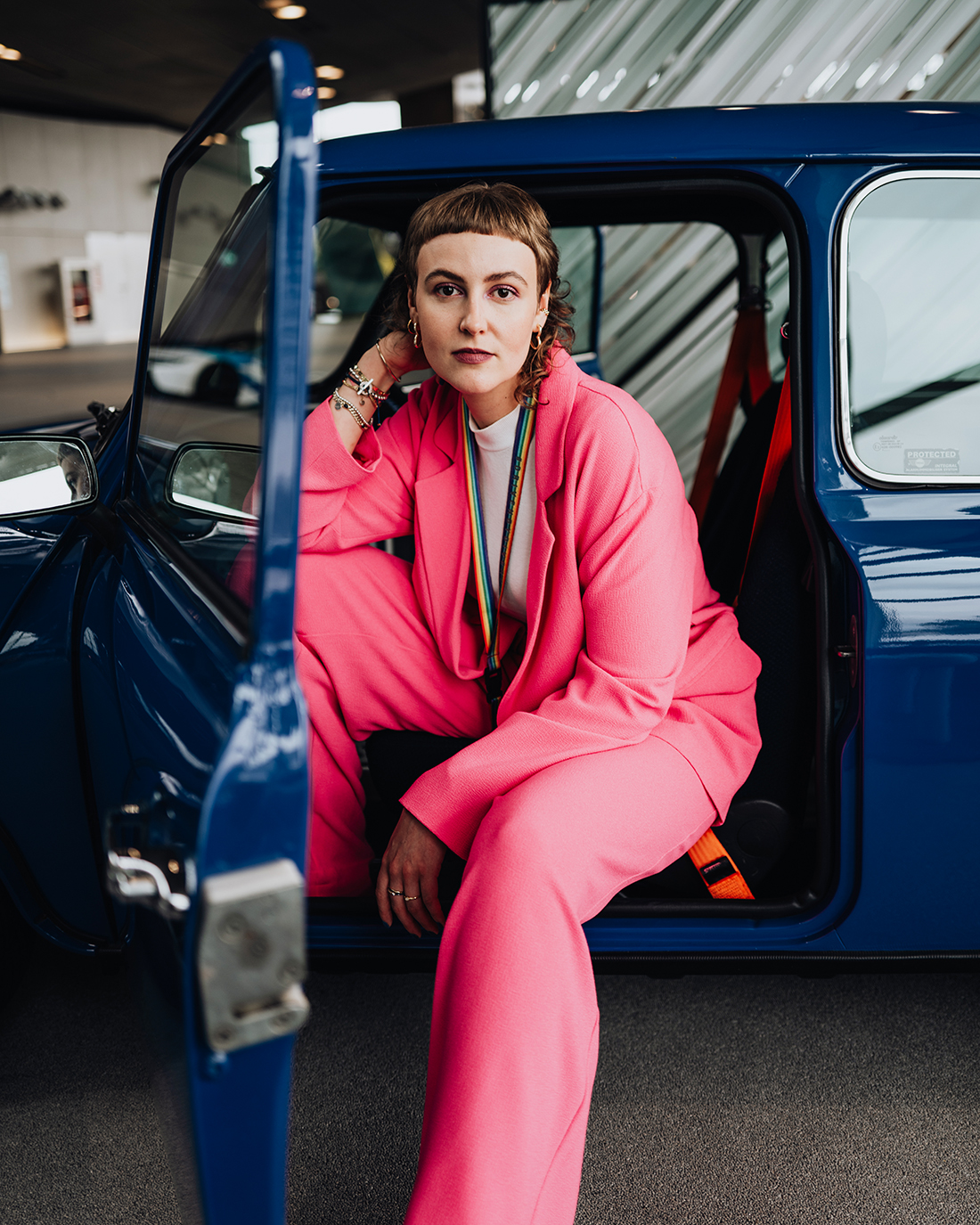 Harriet lehnt sich aus dem Fahrersitz eines Oldtimer MINIs