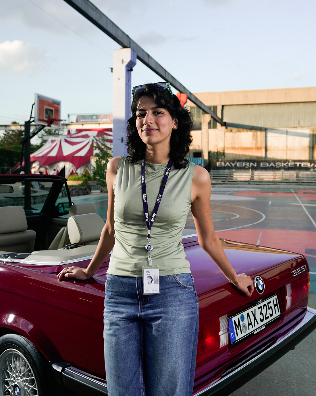 Praktikantin lehnt an einem BMW E30 Cabrio