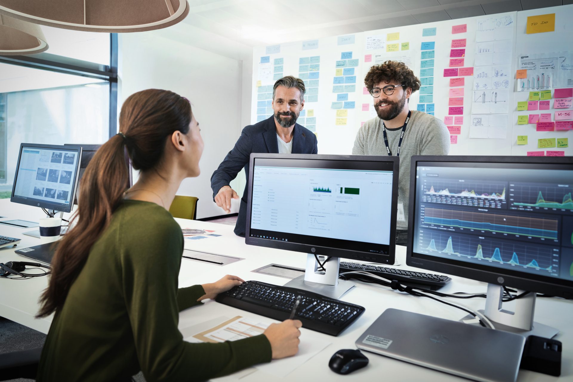 Drei Kolleg:innen unterhalten sich in einem Büro.