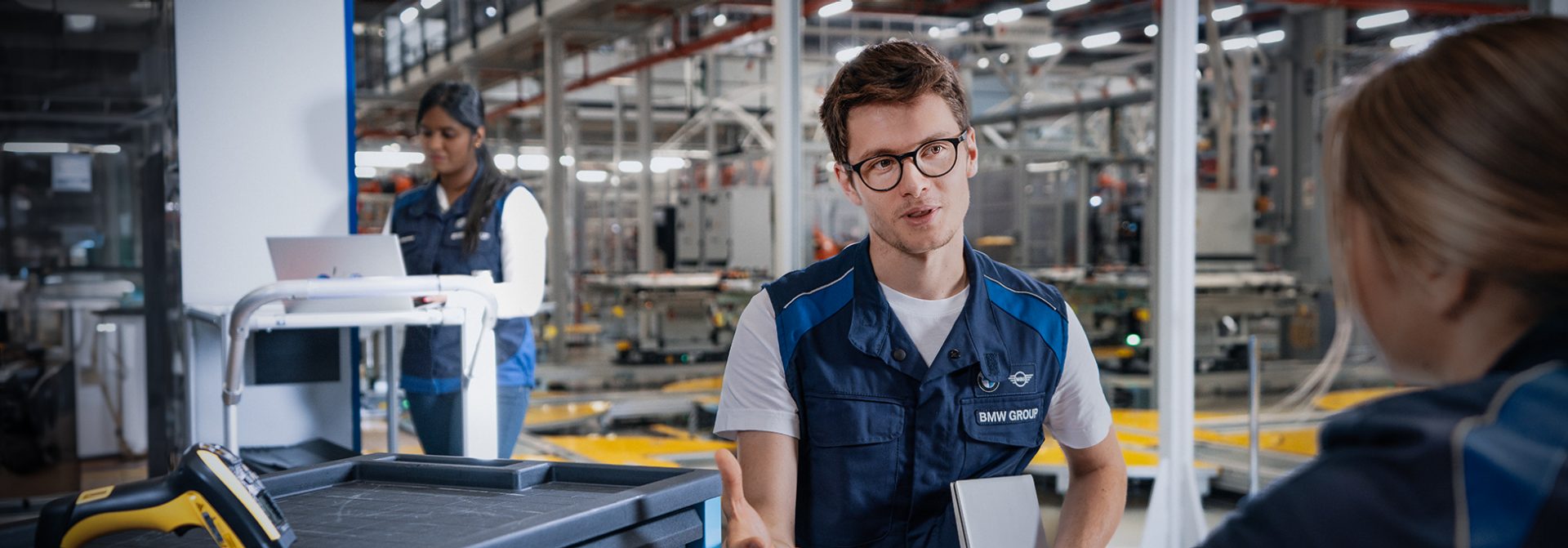 Mitarbeiter der BMW Gruppe führt ein Gespräch mit einer Werkstudentin in der Produktionsstätte.