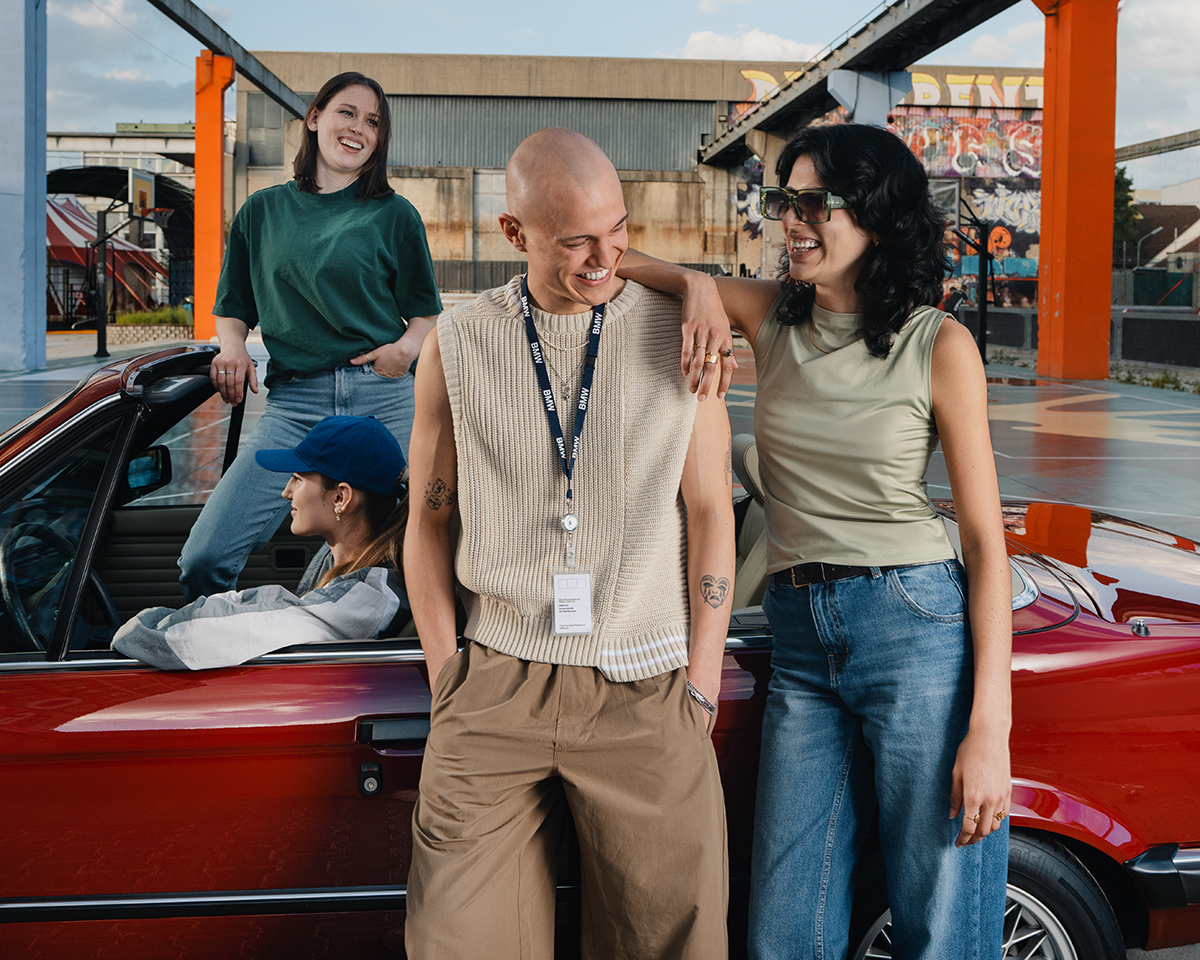 Vier Studenten bei der BMW Group mit einem BMW E30 auf einem urbanen Basketballplatz.