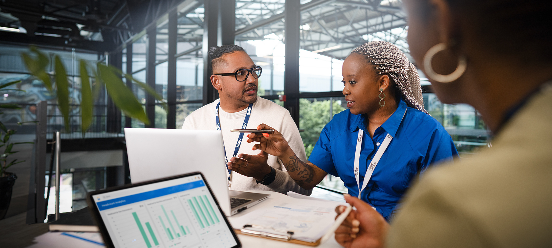 Drei Kolleg:innen sitzen zusammen bei einem Gespräch über die Karriereentwicklung.