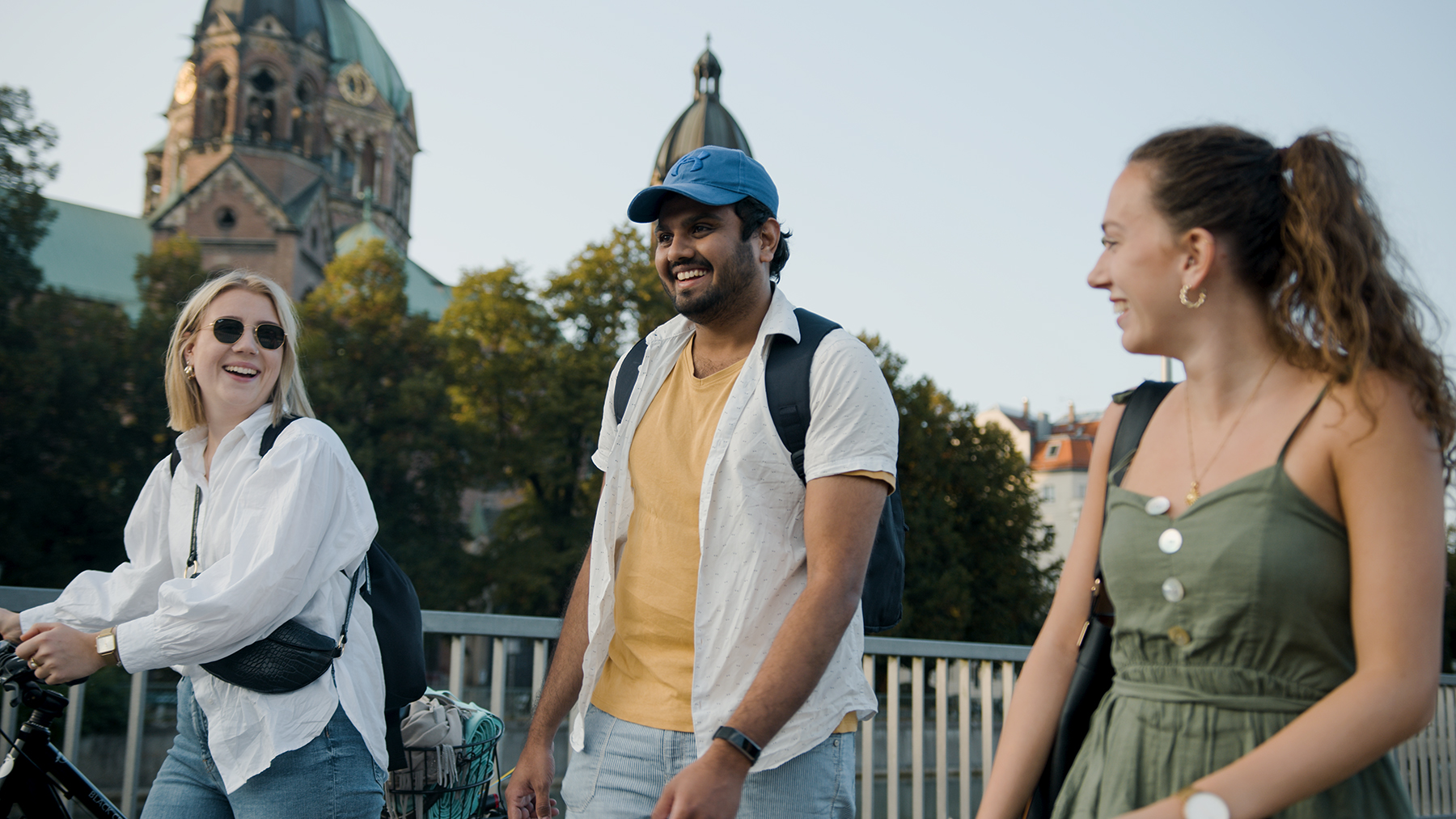 Drei Kolleg:innen der BMW Group bei einem Spanziergang an der Isar in München.