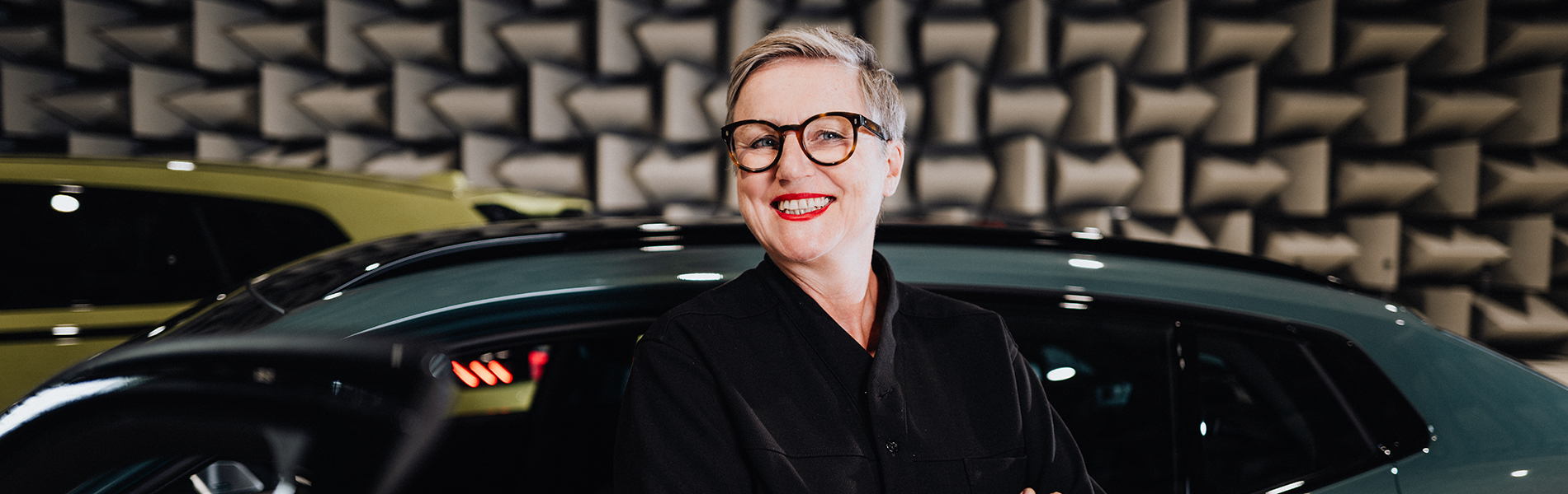 Daniela lächelt vor dem BMW IX2.