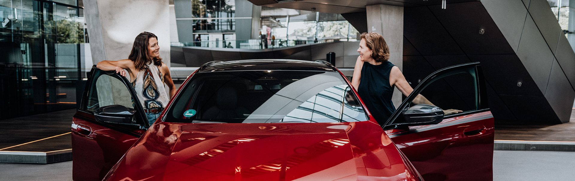Zwei Frauen in Führungspositionen bei der BMW Group steigen aus einem Fahrzeug aus.