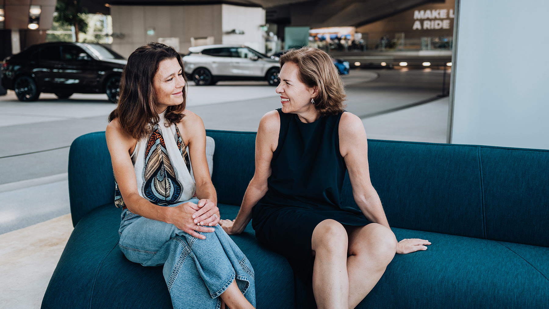 Die Zwei Frauen sitzen zusammen auf einem Sofa und unterhalten sich.