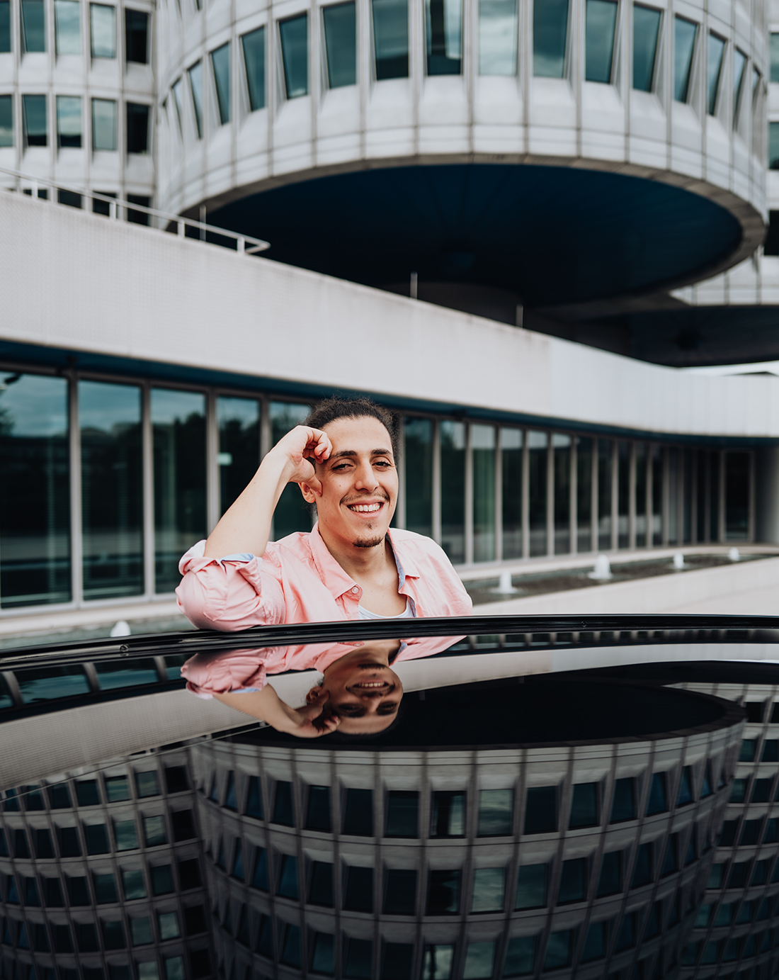 Der BMW Mitarbeiter lehnt sich über das Dach des BMW i5.