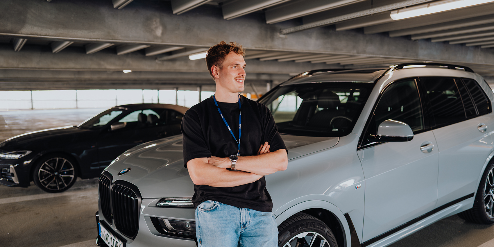 Ingenieur der BMW Group lehnt an dem Kotflügel eines BMW X7.