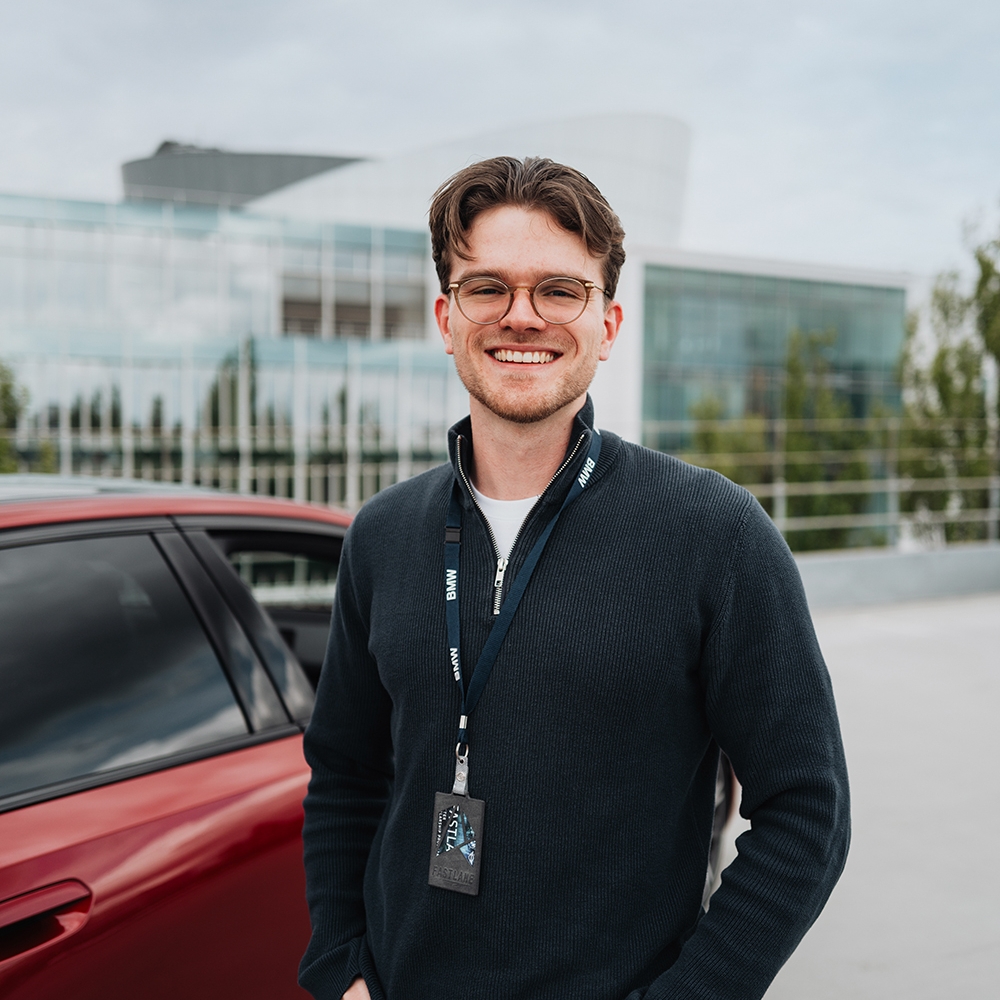 Fastlaner Simon vor einem roten BMW i5