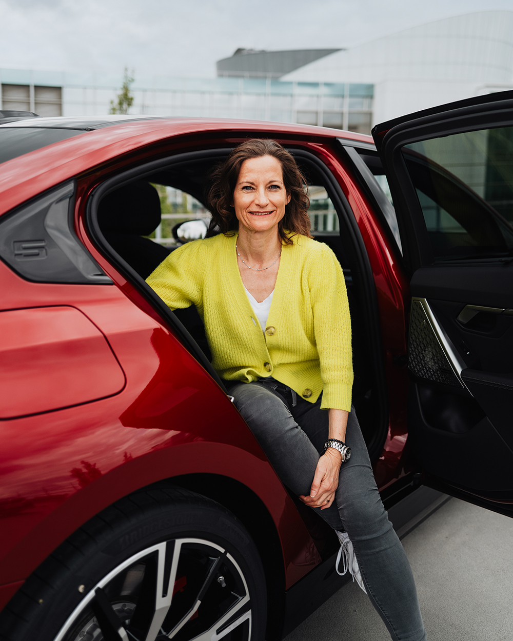 Leiterin Nachhaltigkeit Produktion Sabine in einem roten BMW i5