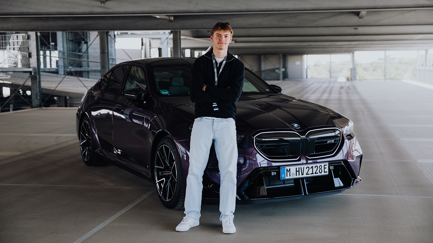 Azubi Tobias vor einem BMW M5 in Lila