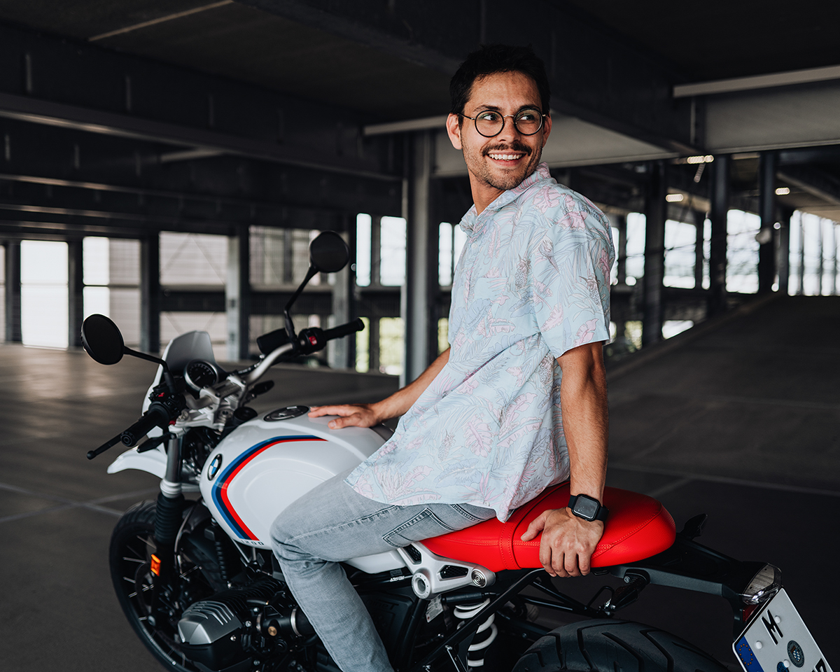 Mitarbeiter auf seinem BMW Motorrad im Parkhaus.