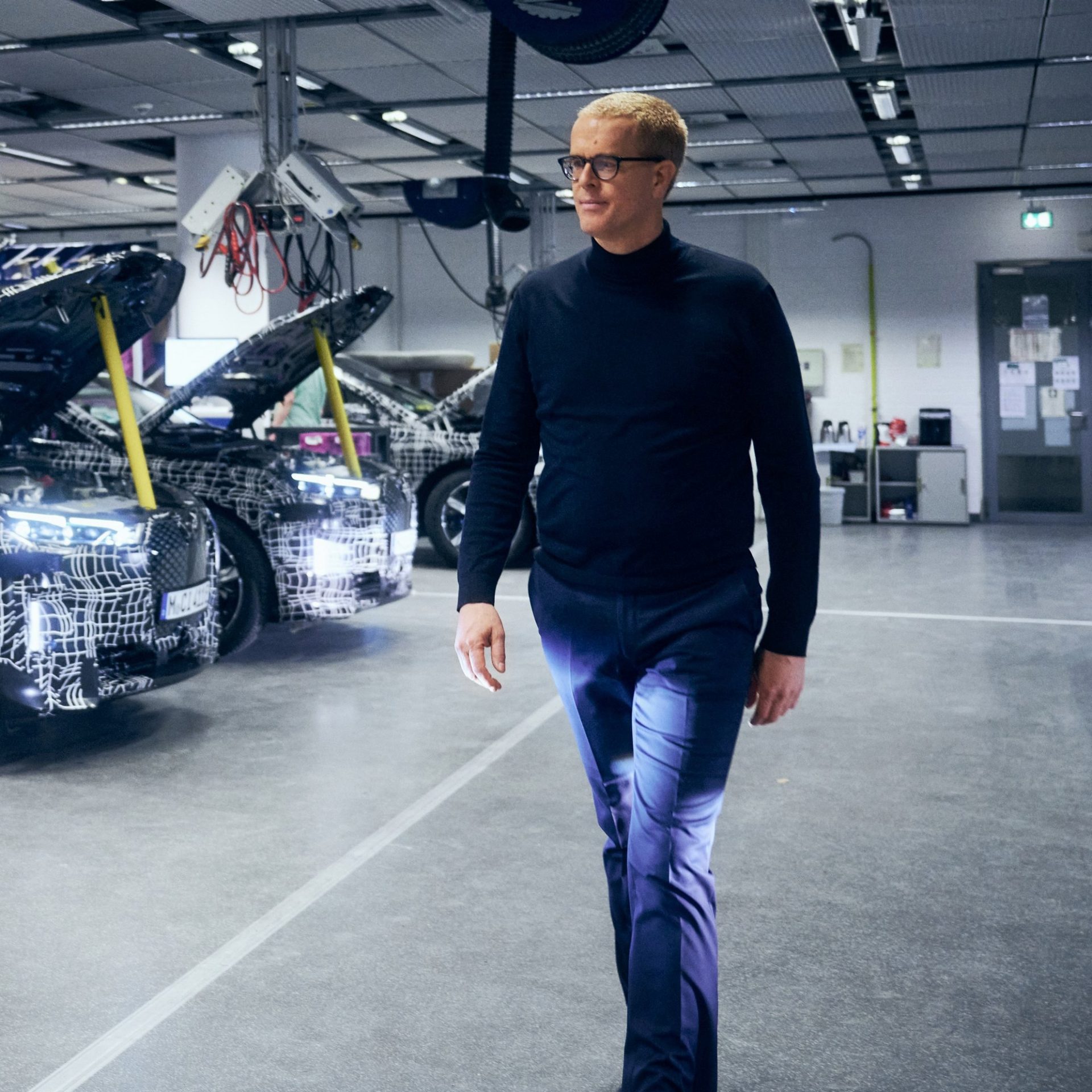 Frank Weber, member of BMW board, walking through the development workshop.