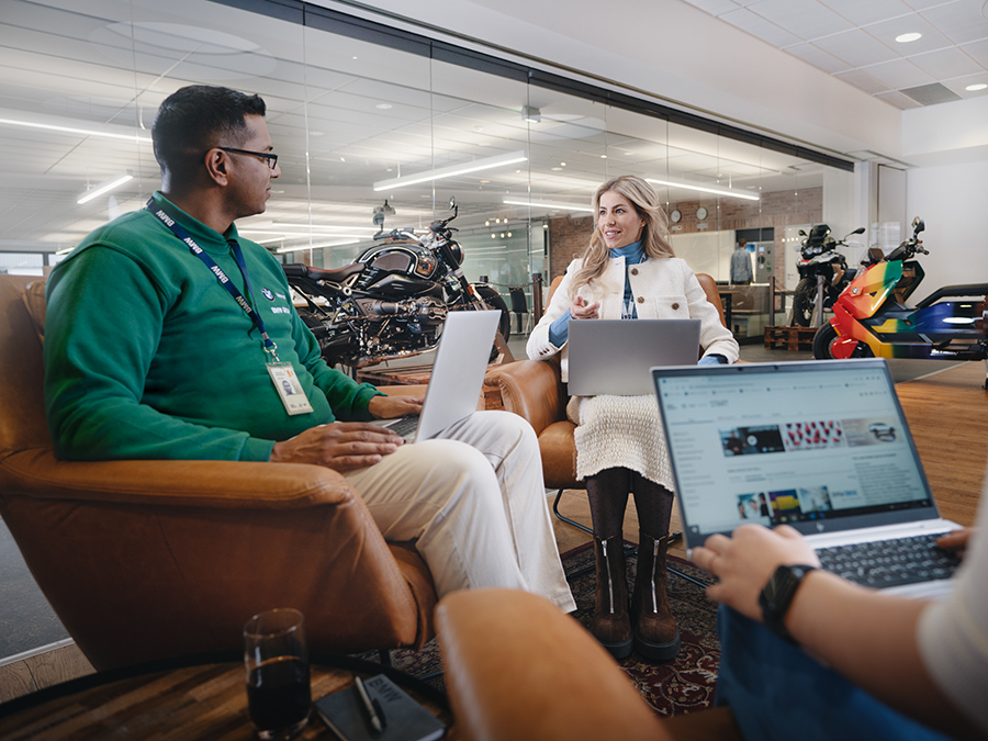 Three colleagues sitting together having a meeting in a modern office environment.