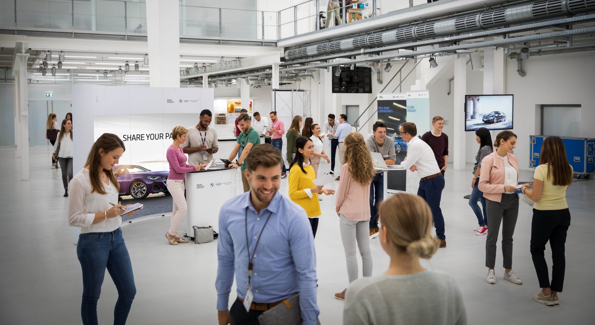 The picture shows a busy showroom at one of the BMW Students Days.