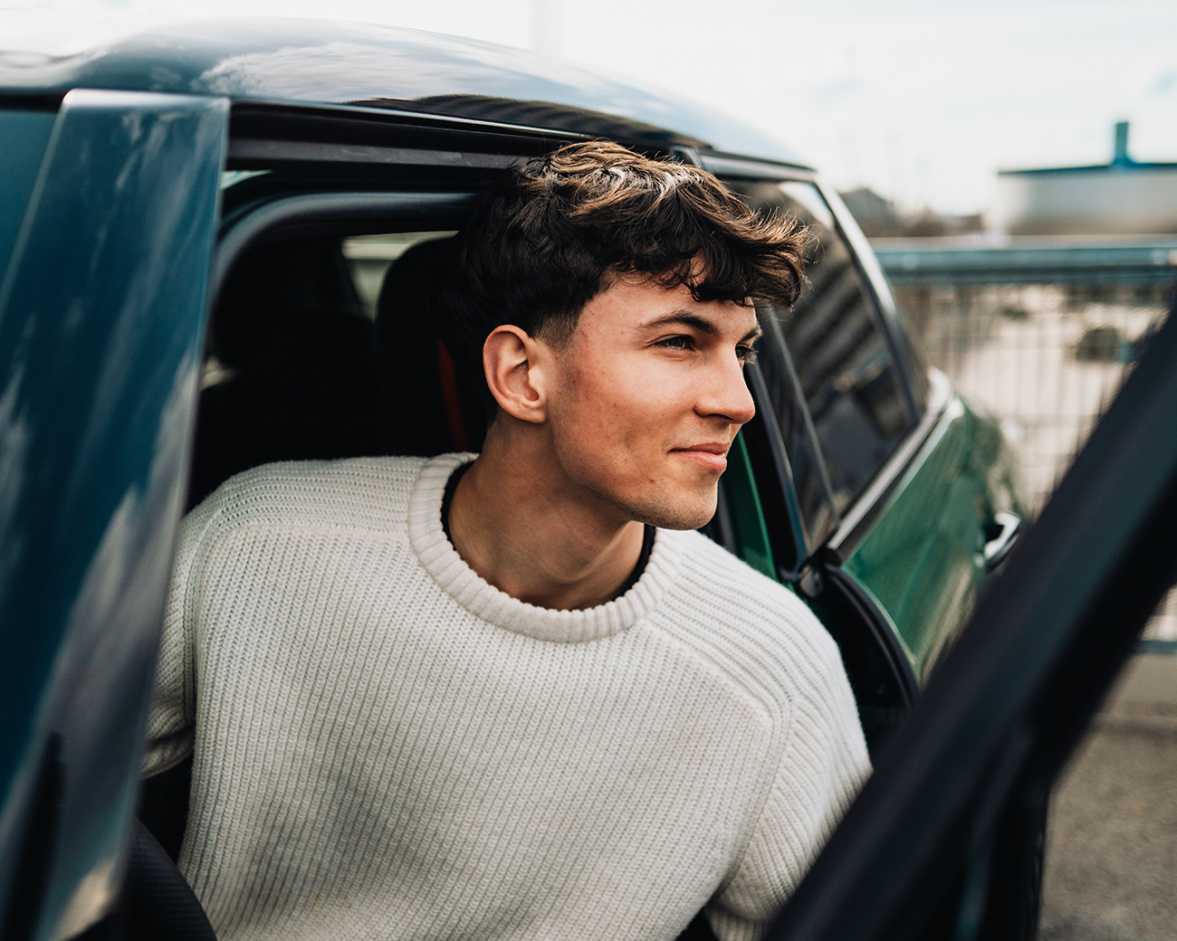 Anton, a work-study student, is sitting in a green MINI Cooper