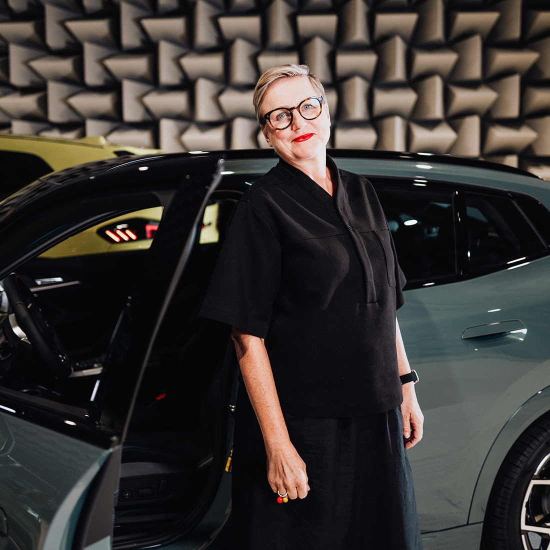 Daniela is standing next to the open driver’s door of the BMW iX2.