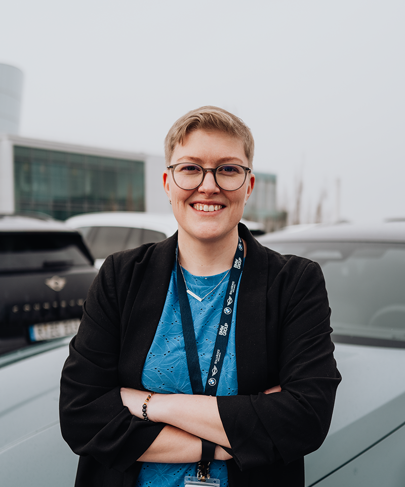PhD student Erla stands in front of the BMW i5.