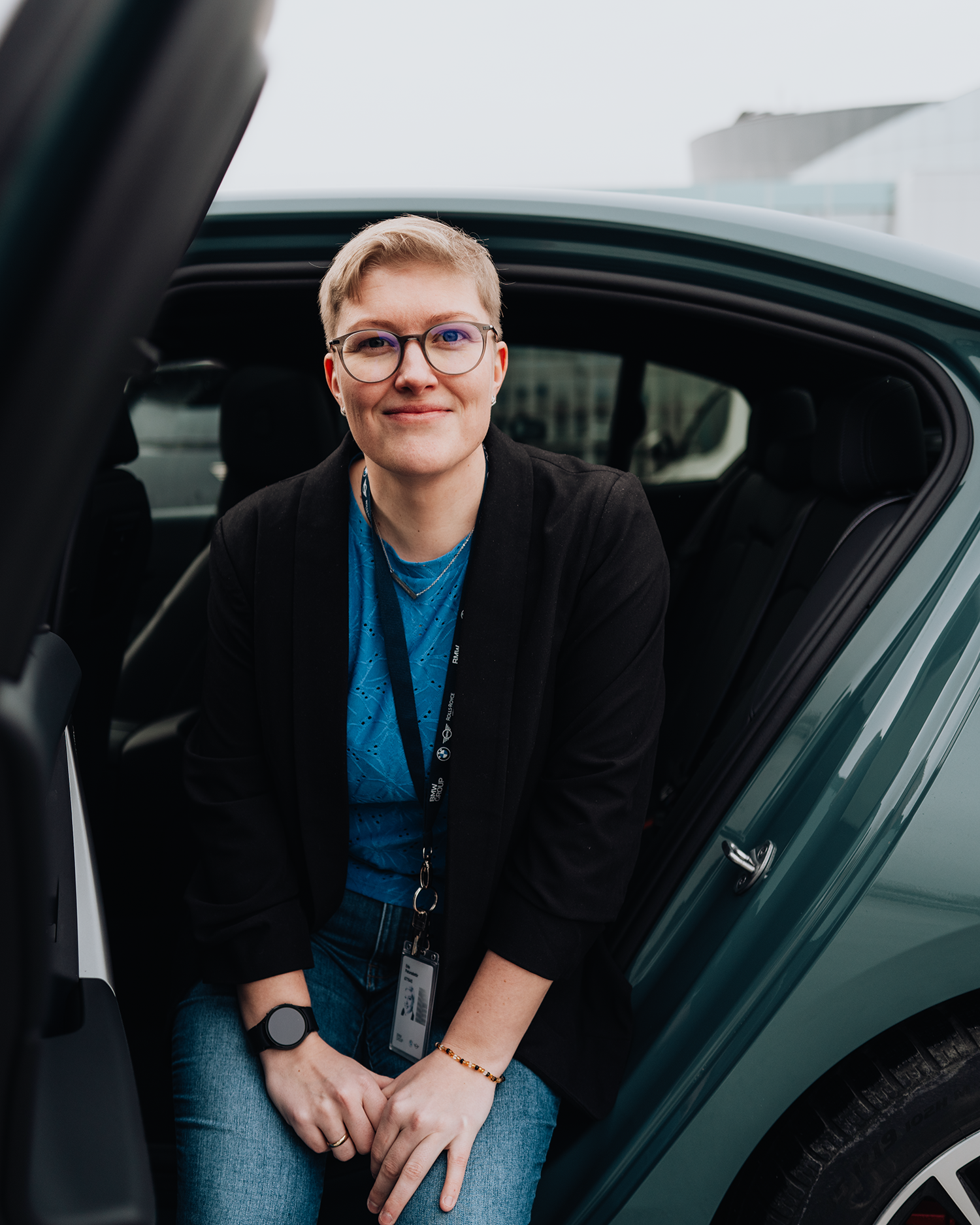 PhD student Erla sits in the back seat of a BMW i5.