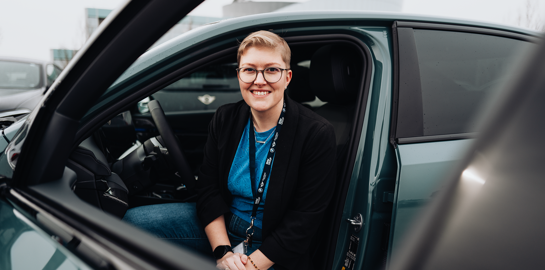 Erla sits in the driver's seat of a BMW i5.