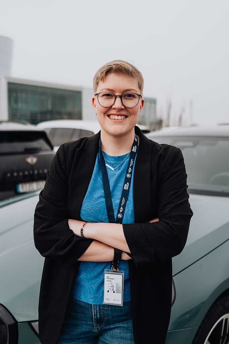 PhD student Erla stands in front of the BMW i5.