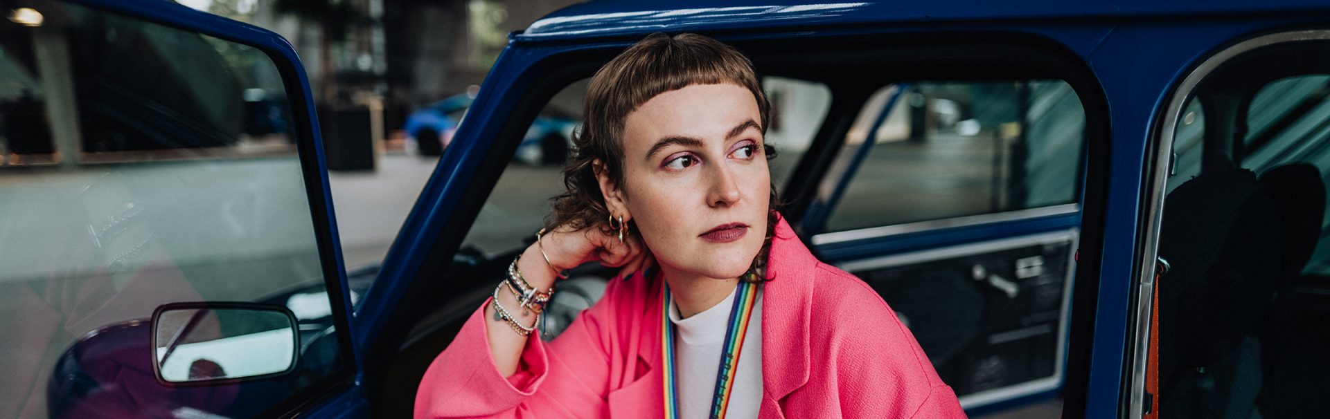 Female Intern with a pink suit sitting in a historical MINI.