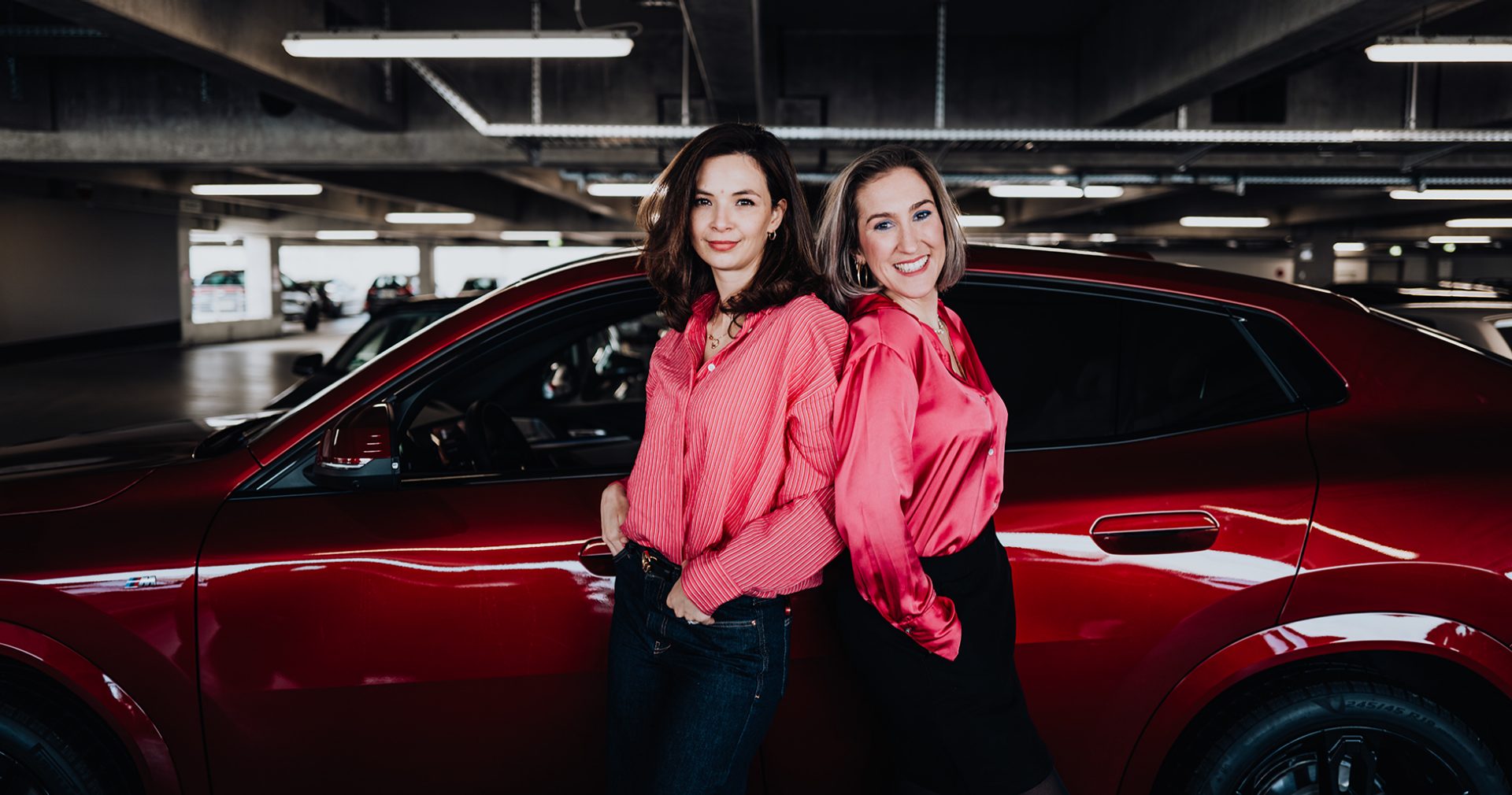BMW employees Julia and Denise with a red BMW X2