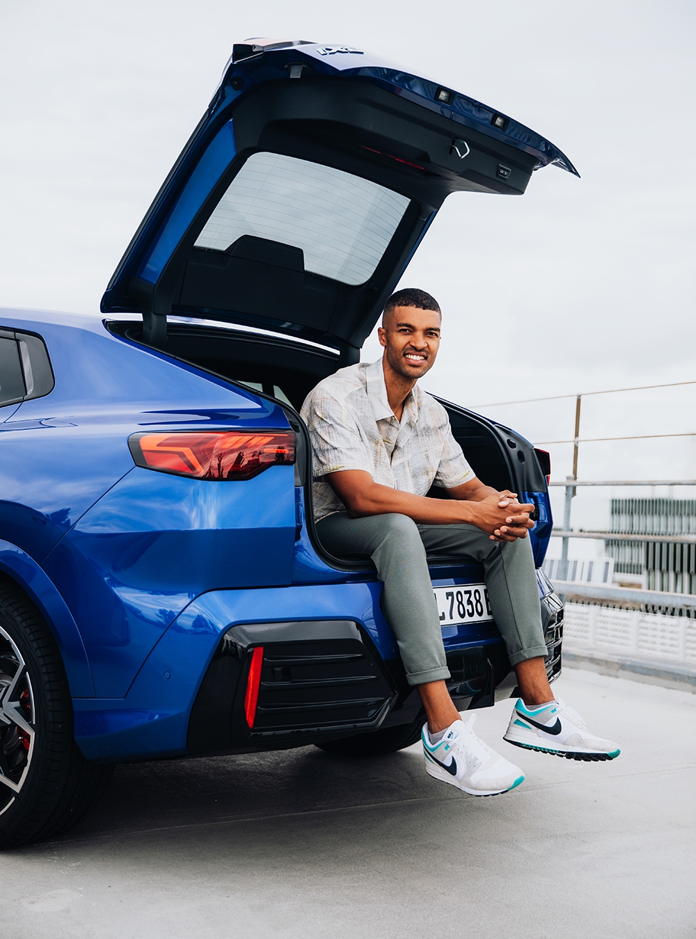 Engineer at the BMW Group sitting in the trunk of a car.